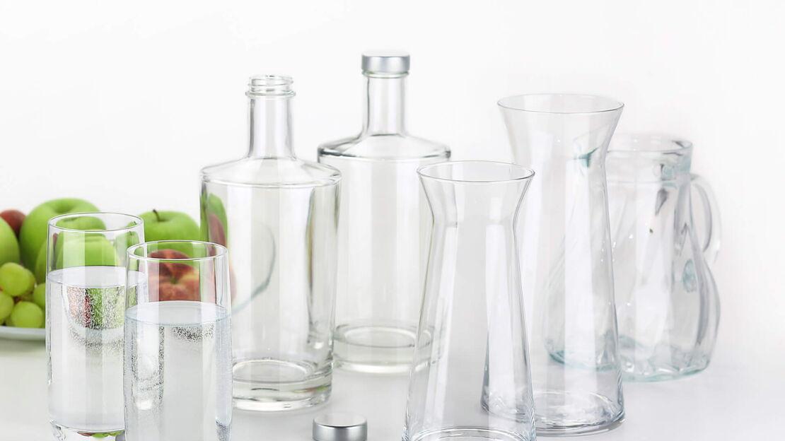 Mehrere Glasflaschen und Karaffen stehen auf einem Tisch.