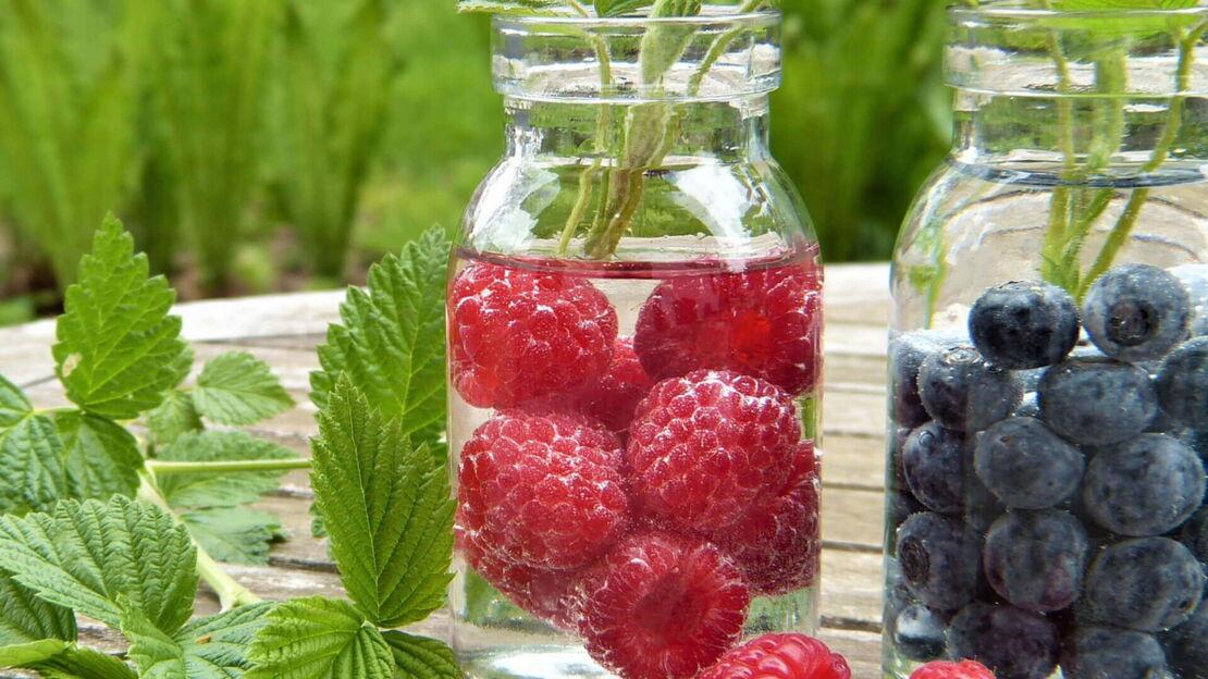 Himbeeren und Blaubeeren in einem Wasserkrug