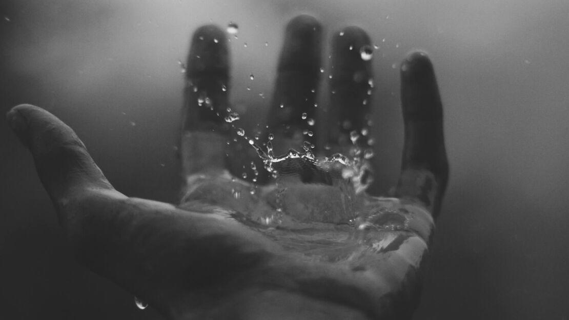 Wasserspritzer auf offener Handflaeche
