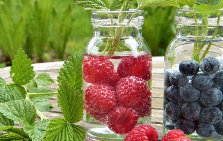 Himbeeren und Blaubeeren in einem Wasserkrug