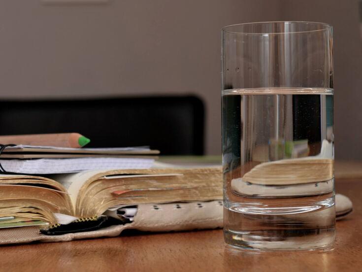 Ein Buch und ein Glas Wasser auf einem Tisch