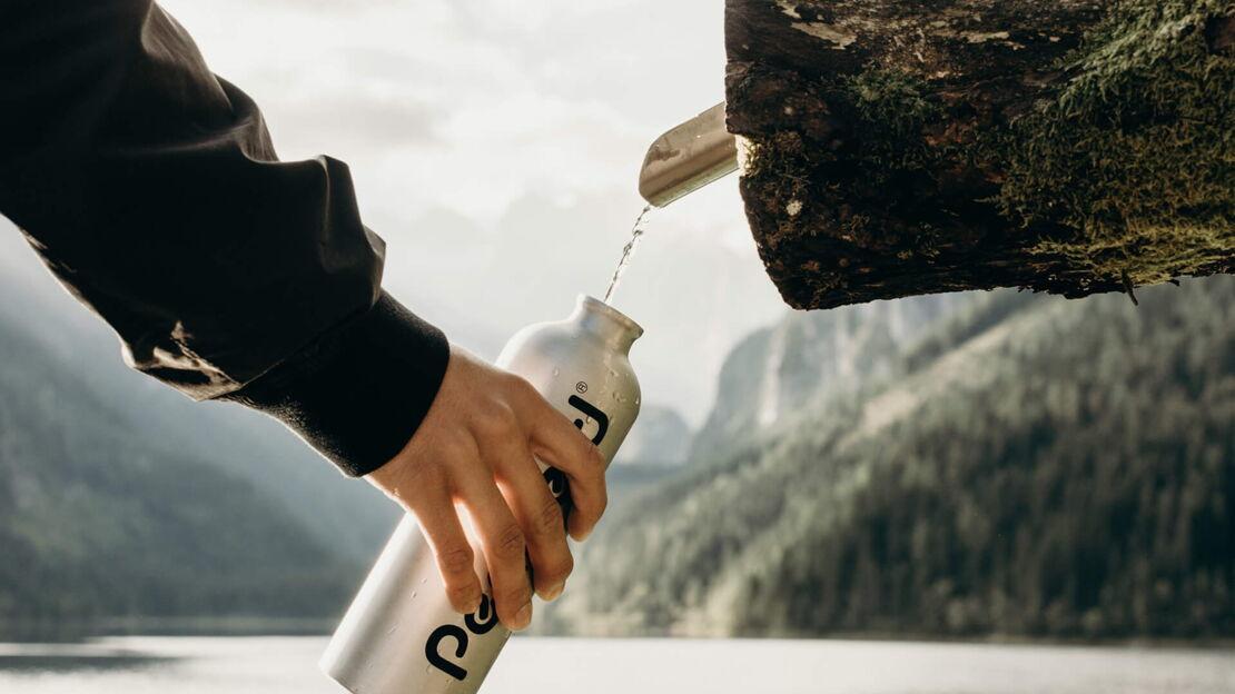 Wasser tropft in eine Flasche