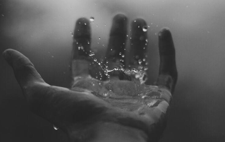 Wasserspritzer auf offener Handflaeche