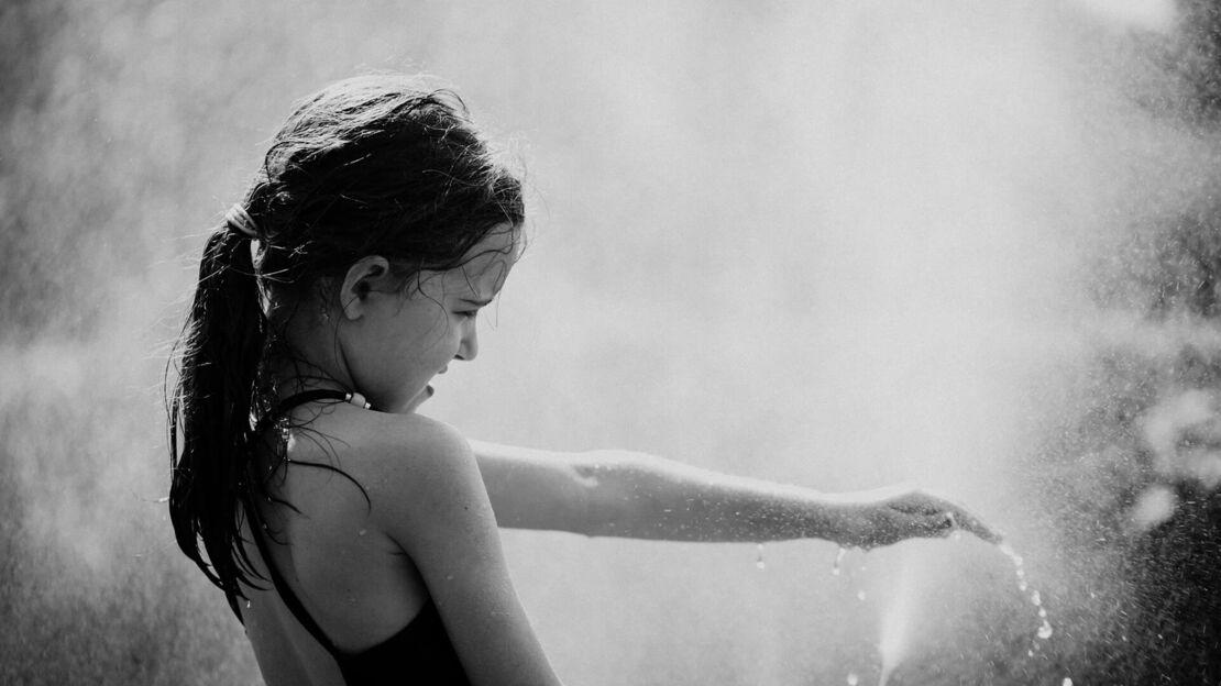 Mädchen spielt mit Wasser