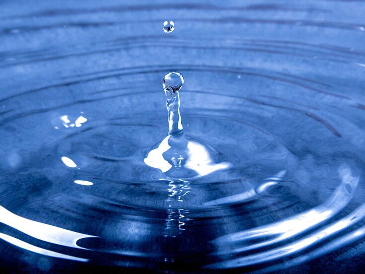 Ein blauer Wassertropfen auf einer Wasseroberfläche