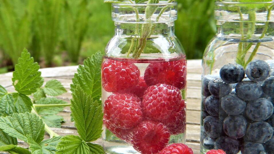 Himbeeren und Blaubeeren in einem Wasserkrug