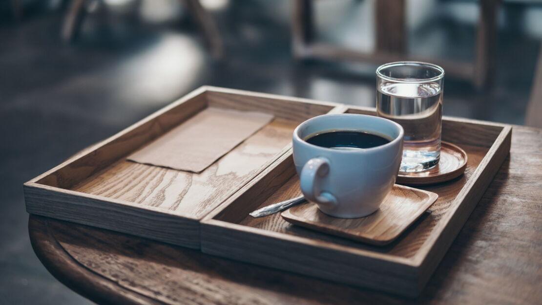 Kaffee und Wasser auf einem Tablett serviert