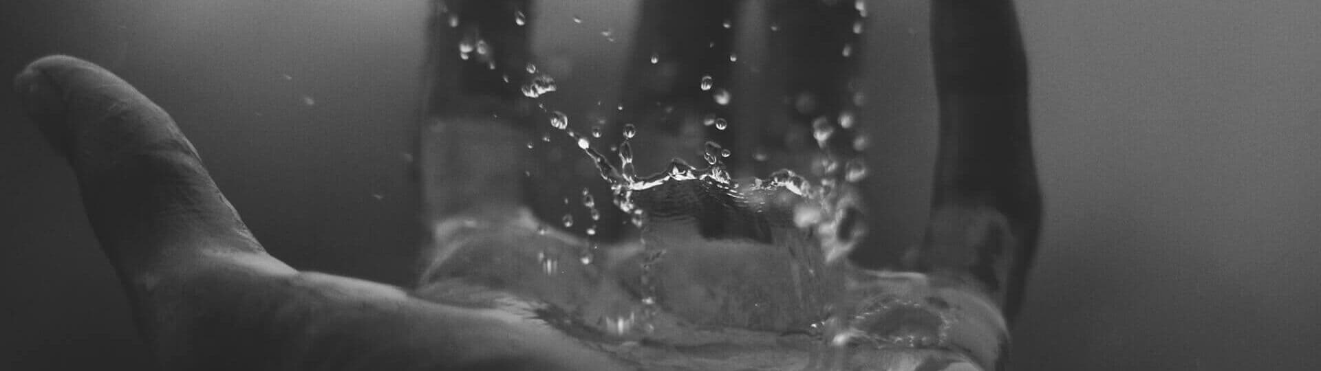 Wasserspritzer auf offener Handflaeche