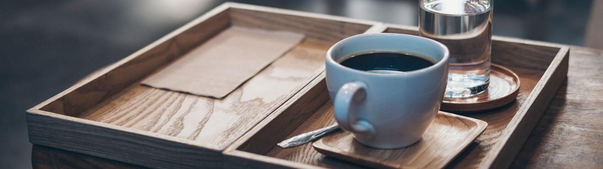 Kaffee und Wasser auf einem Tablett serviert