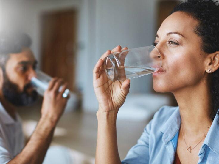 Frau und Mann trinken Wasser aus einem Glas