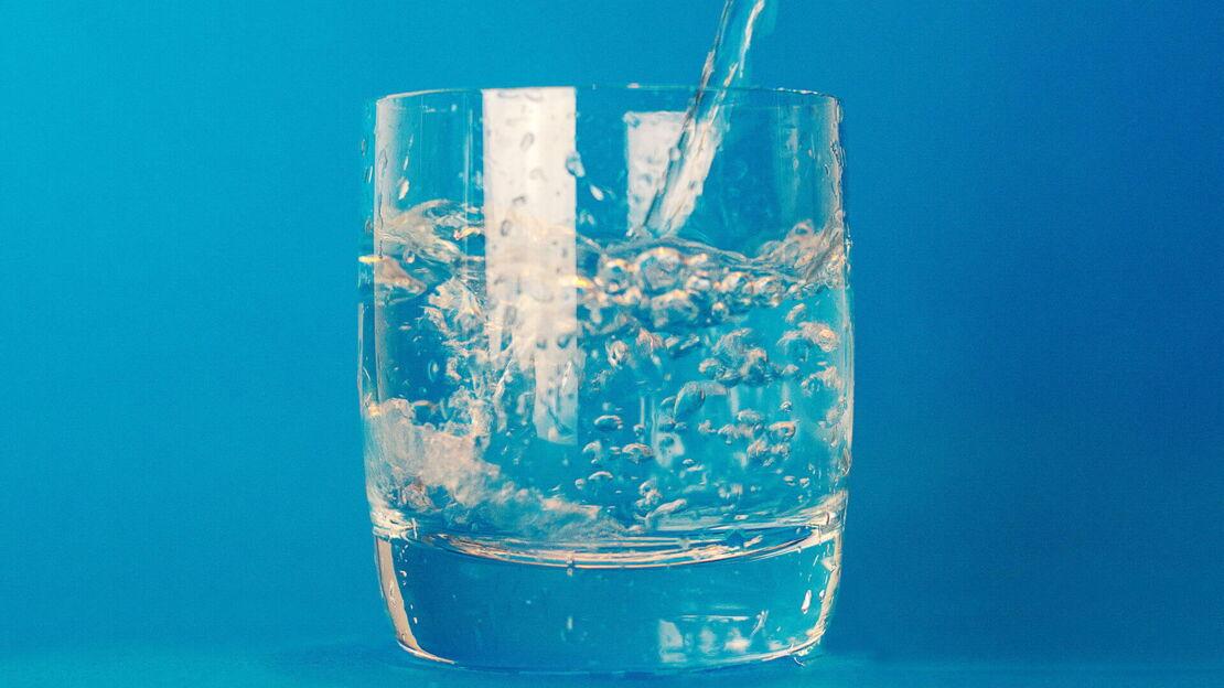 Wasserglas auf blauem Hintergrund