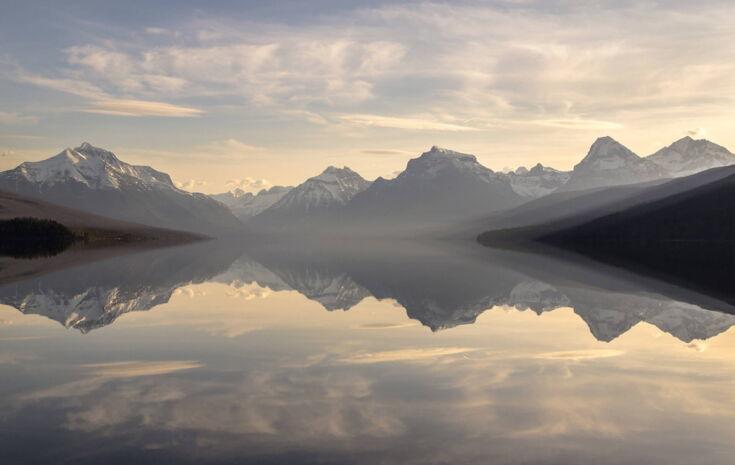 Gebirge spiegelt sich in glatter Wasseroberfläche