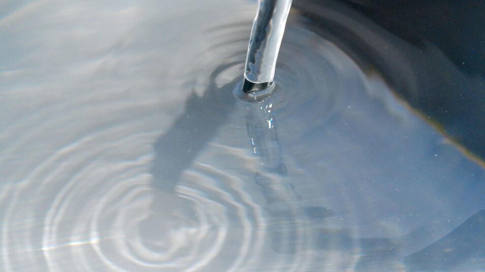 Wasserstrahl fließt in Becken