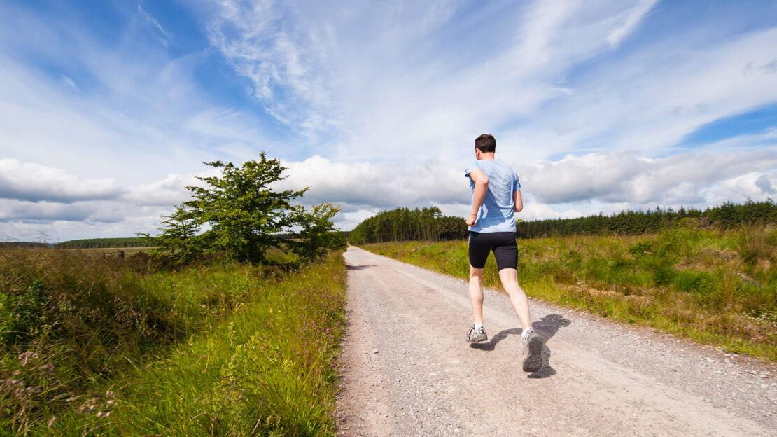Ein Mann joggt einen Weg entlang