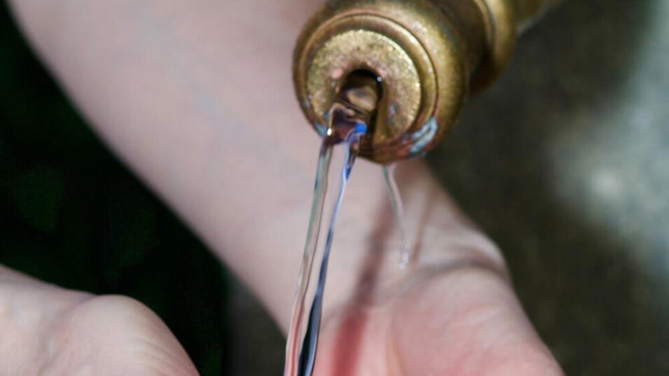 Wasser fliesst in zusammengenommene Haende