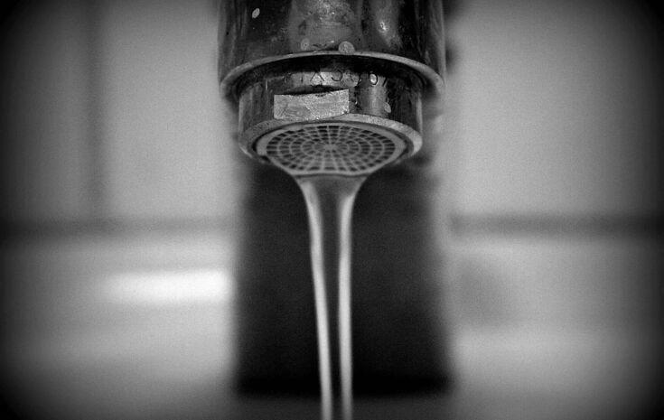 Aus Wasserhahn fließt langsam Wasser