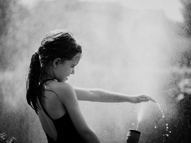 Mädchen spielt mit Wasser