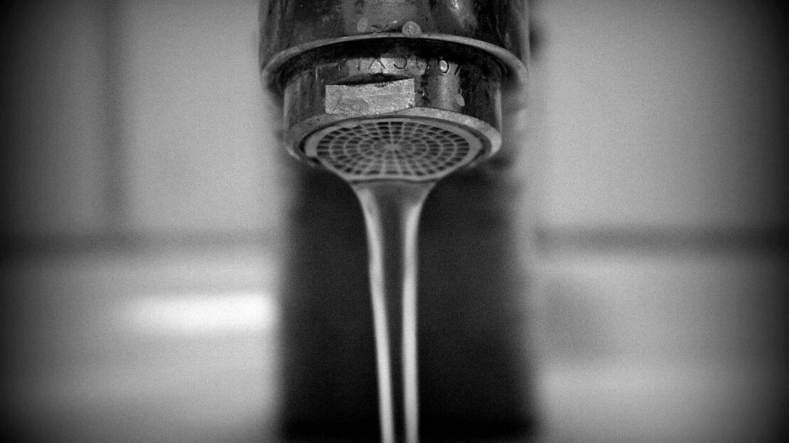 Aus Wasserhahn fließt langsam Wasser